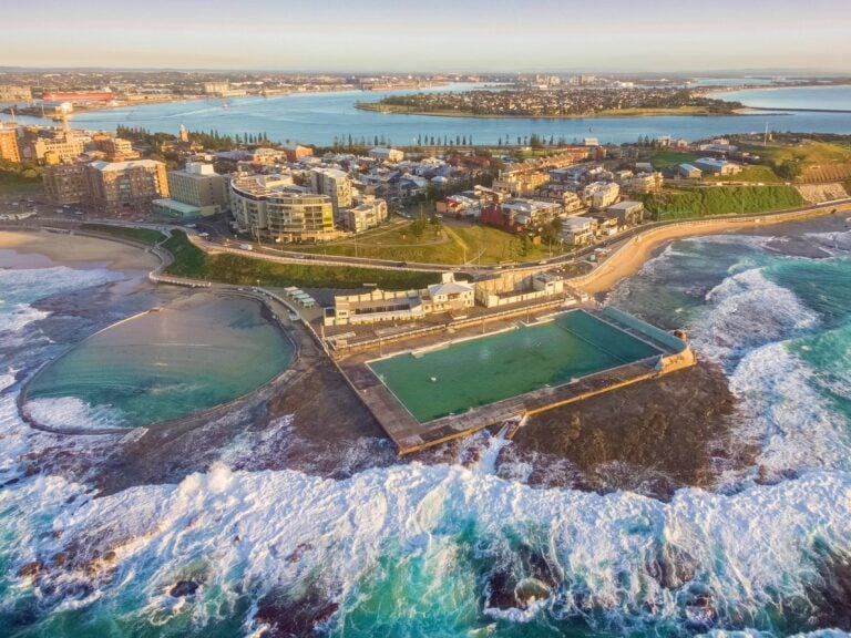 aerial,shot,of,sun,rising,over,the,newcastle,ocean,baths,
